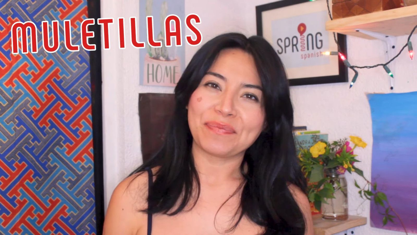 Female instructor discussing Spanish filler words with 'Spring Spanish' logo in the background; keyword 'Spanish filler words' emphasized by the text 'Muletillas' on screen.